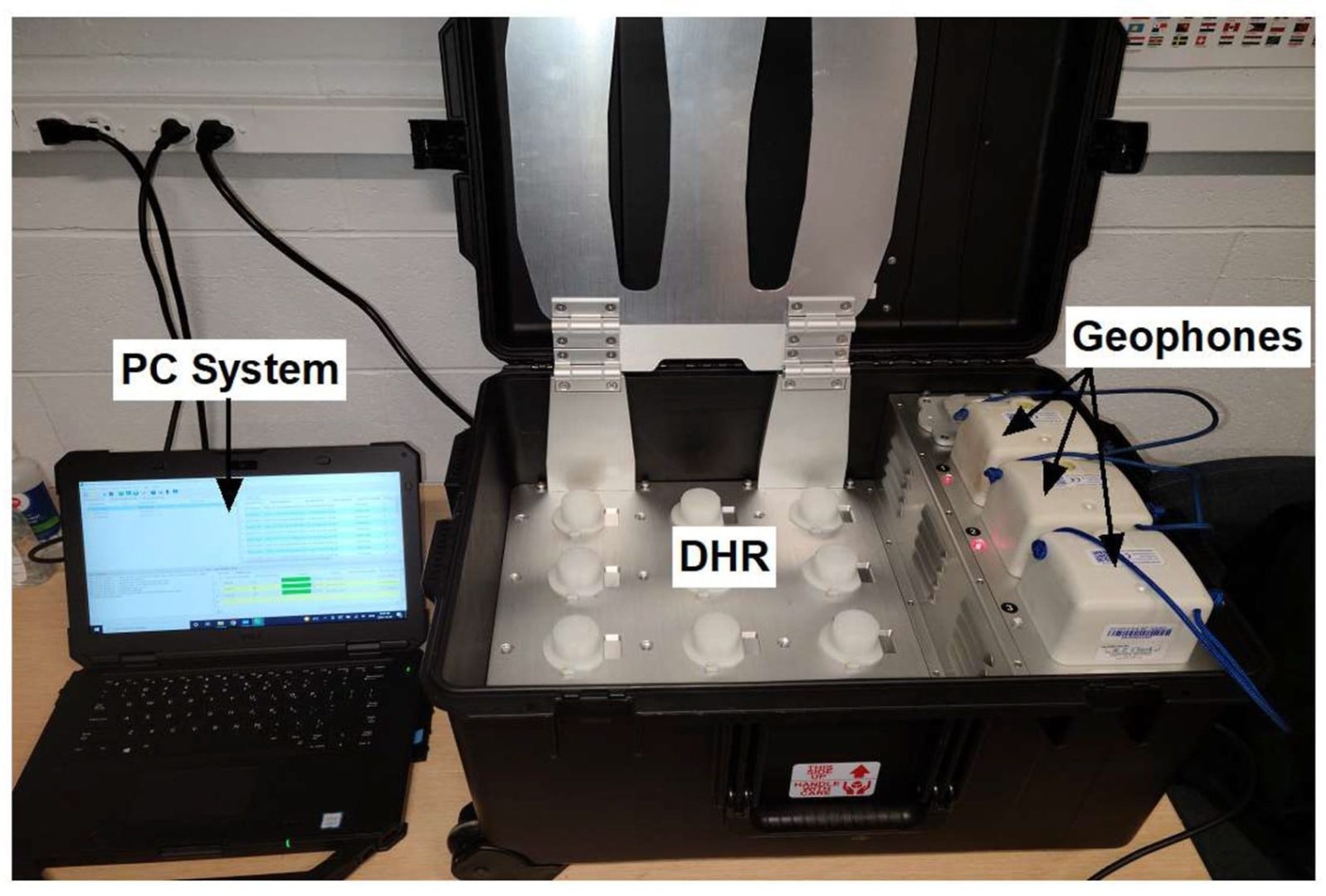 A PC system is connected to a DHR case containing geophones, which are seismometers used for geophysical exploration and seismic survey.