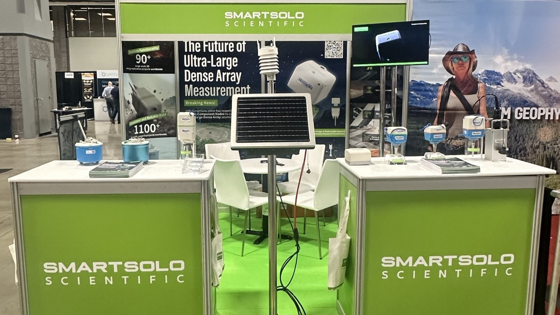 SmartSolo Scientific booth displaying seismometer nodes and solar panels for geophysical exploration and seismic surveys. Text: "The Future of Ultra-Large Dense Array Measurement".