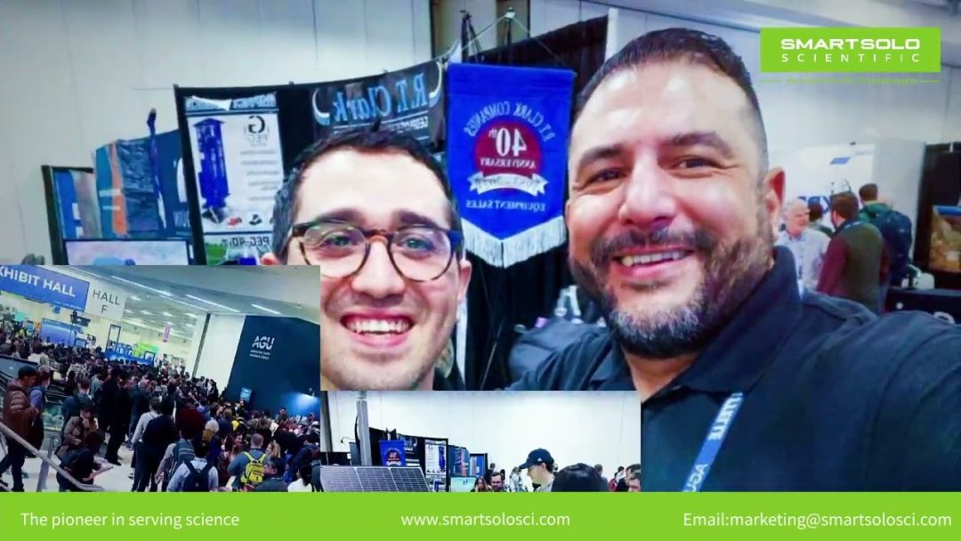 Two men smile at a conference booth with seismic instruments. Text: SMART SOLO SCIENTIFIC, The pioneer in serving science.