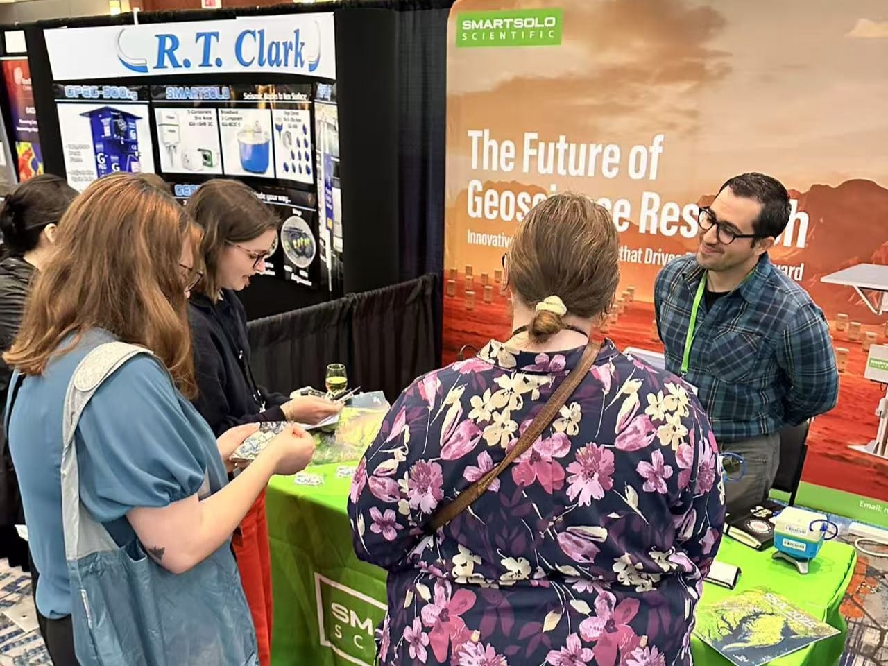 Attendees at the SmartSolo Scientific booth discussing seismic nodes and geophysical exploration technology.