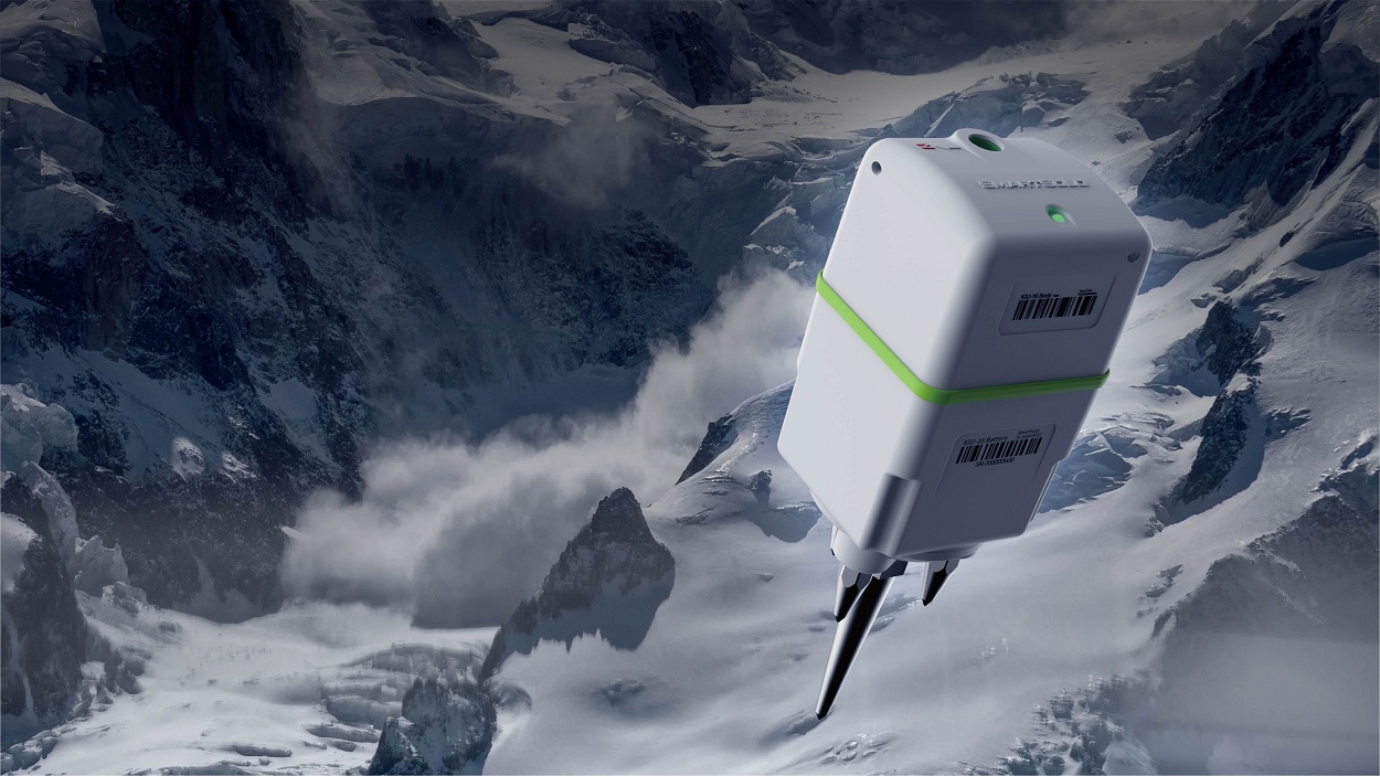 A SmartSolo seismic node with spikes, set against a snowy mountain backdrop, highlighting its rugged design for geophysical surveys in challenging terrains.
